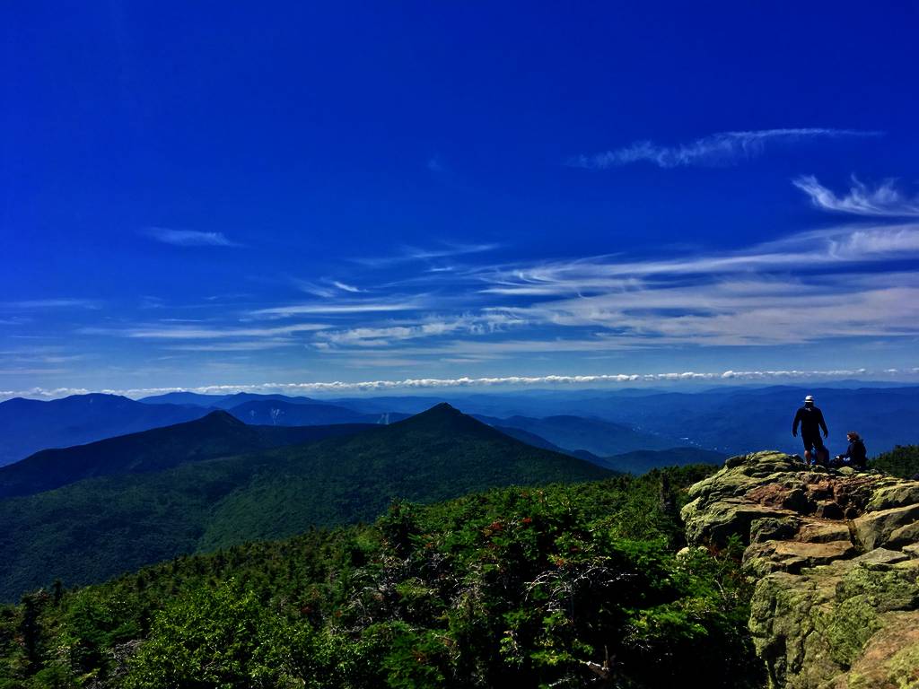 hikers on top of a mountain on a sunny day