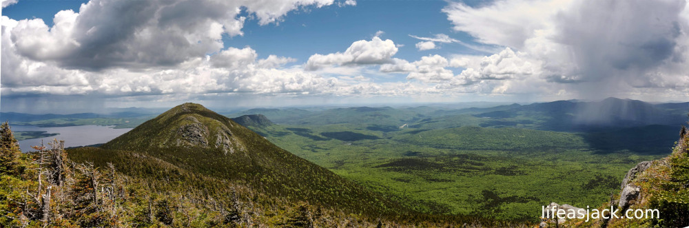 storms approach a mountain range under cloud filled skies.