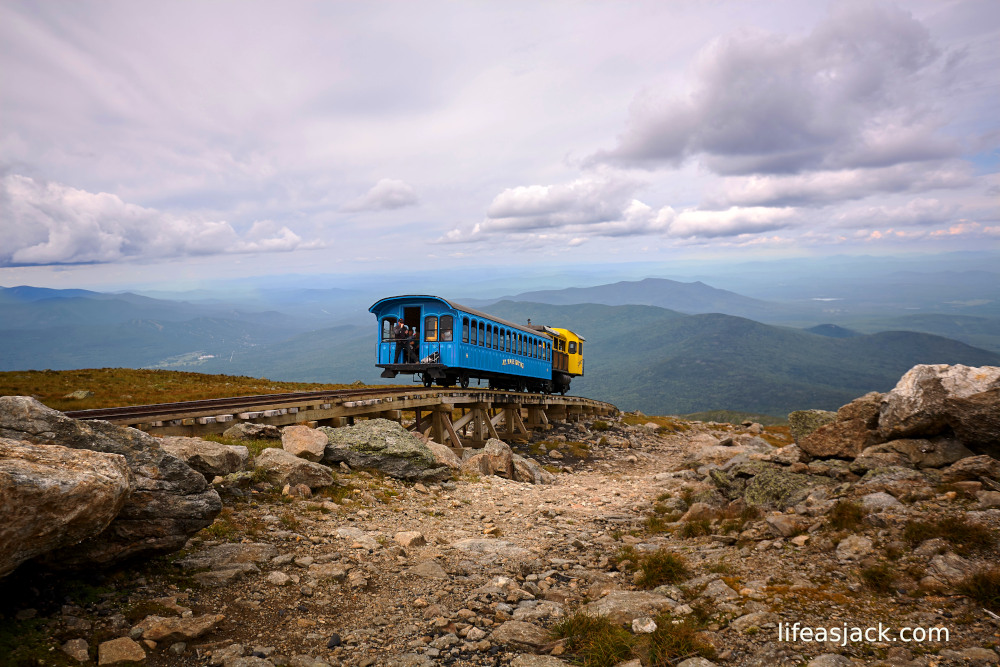 a train engine with a rail car climbing a steep mountain